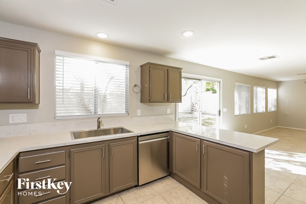 a kitchen with brown cabinets and a sink and a window