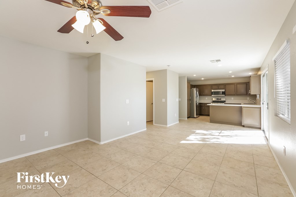 a spacious living room and kitchen with a ceiling fan