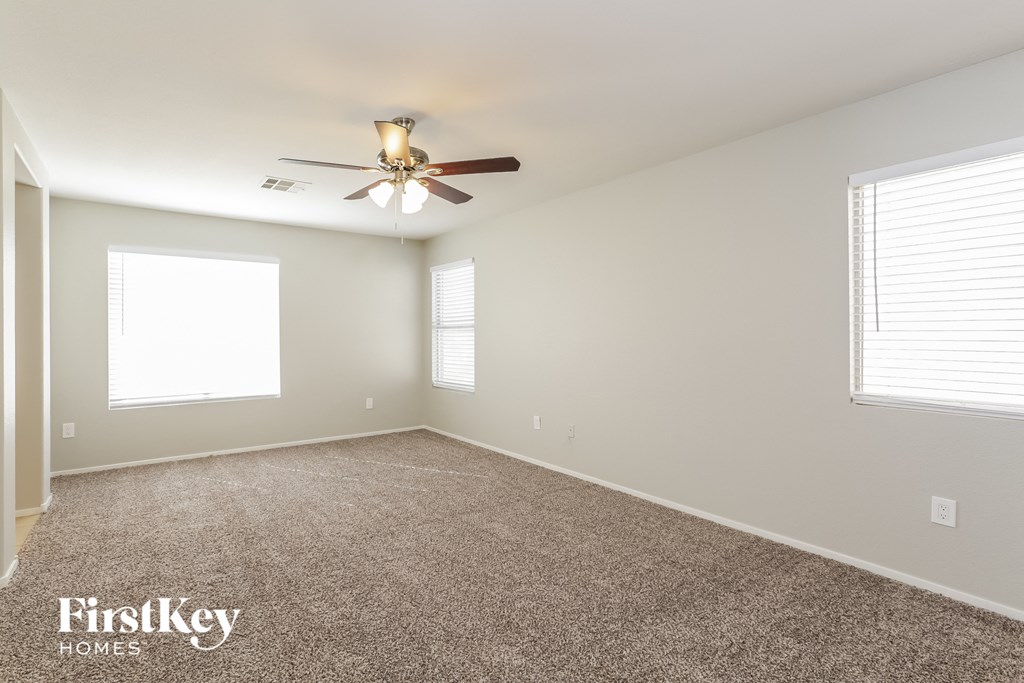 an empty room with a ceiling fan and a window
