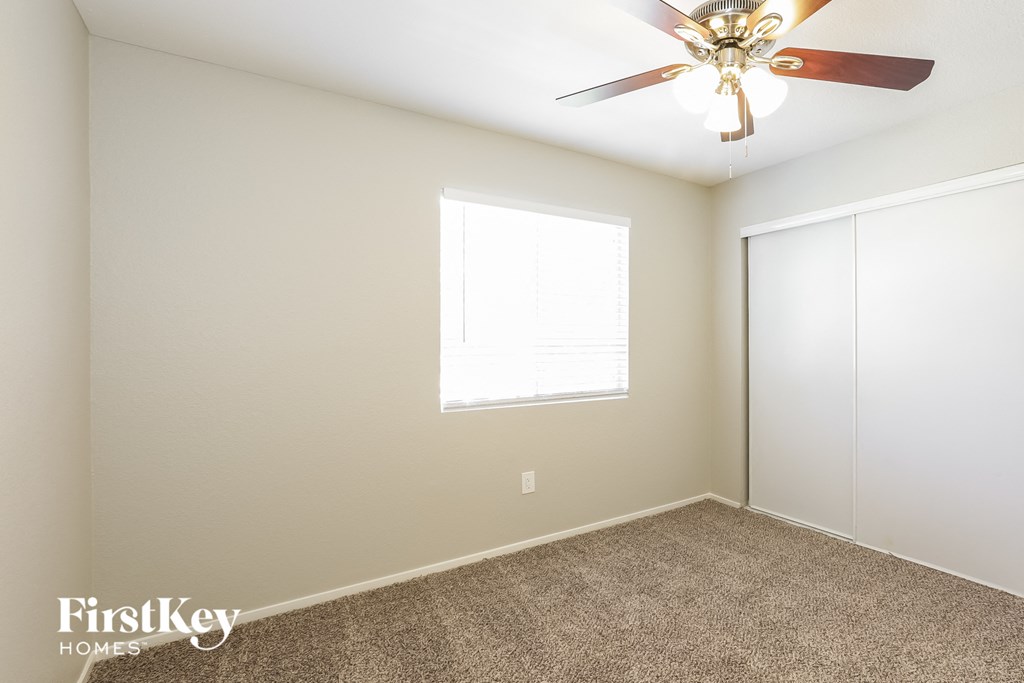 a bedroom with a ceiling fan and a closet