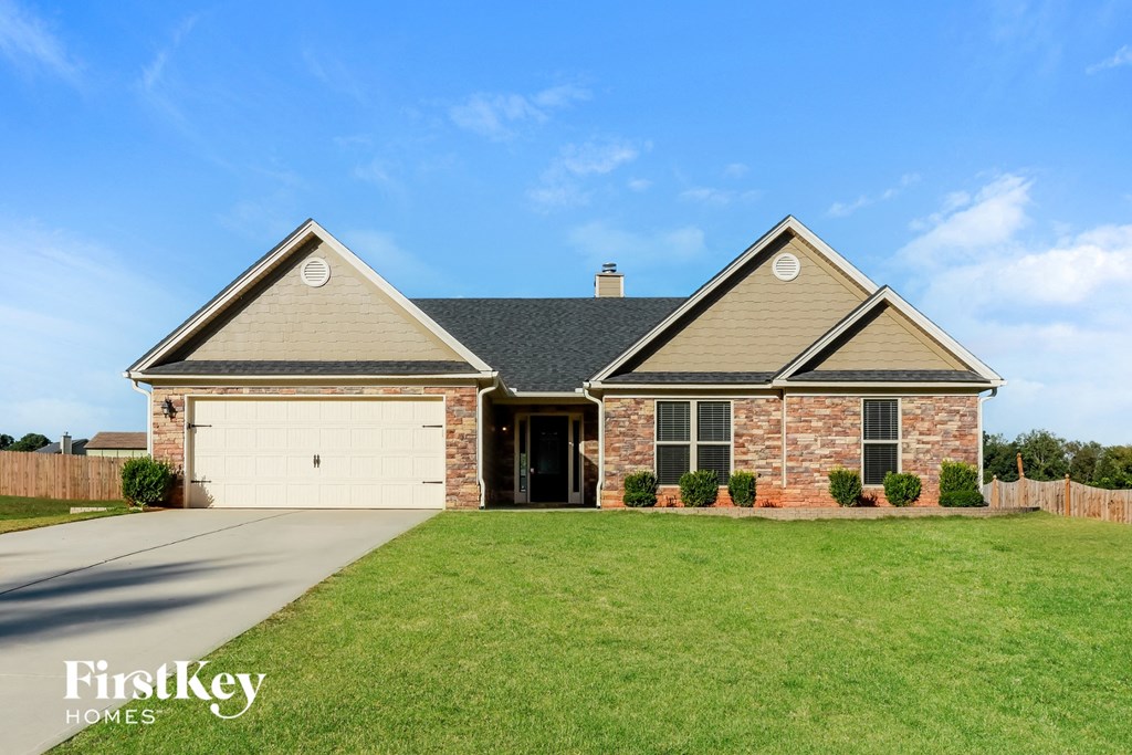 A house with a garage and a brick wall.