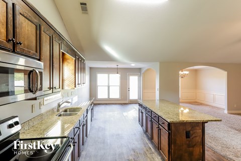 A kitchen with wooden cabinets and a granite countertop.