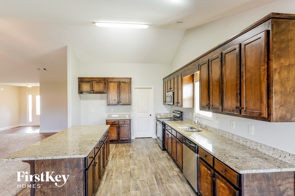 A kitchen with wooden cabinets and a marble countertop.