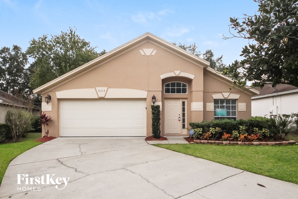 A beige house with a garage door and a window.