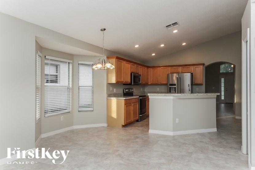 A kitchen with wooden cabinets and a white island.