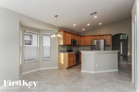 A kitchen with wooden cabinets and a white island.
