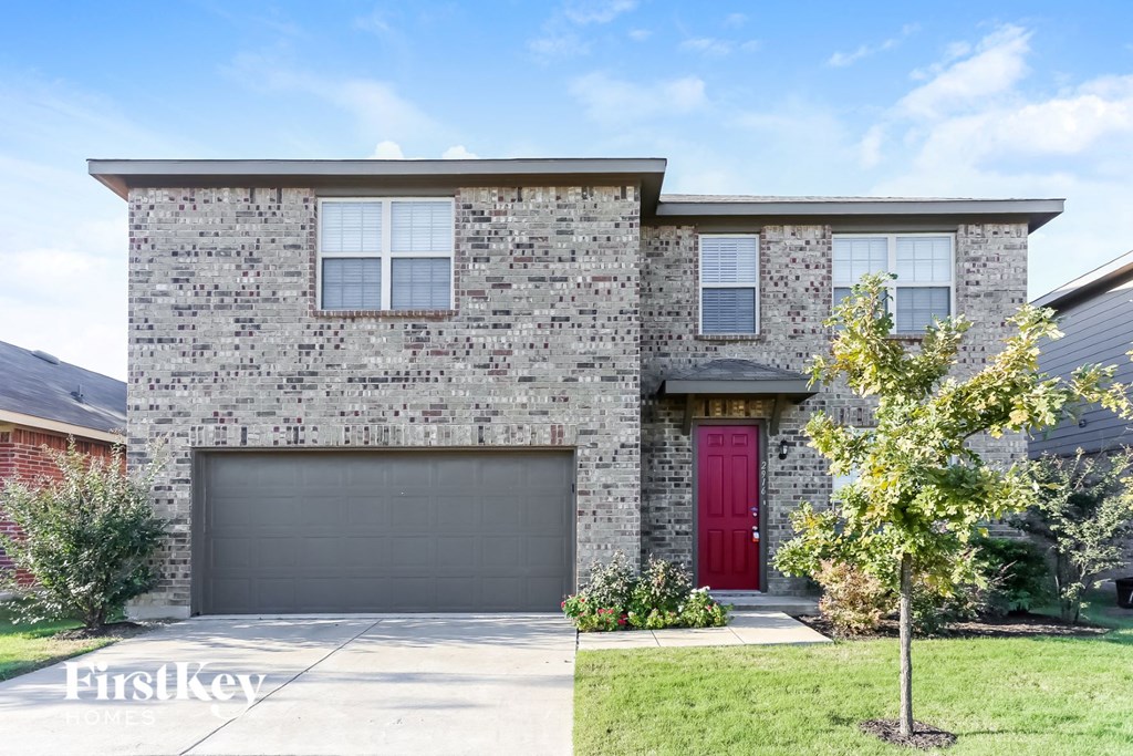 a brick house with a red door and a garage door