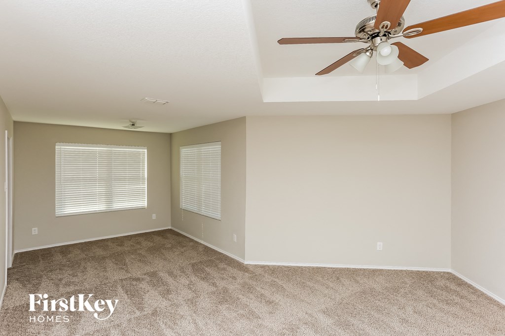 a living room with carpet and a ceiling fan