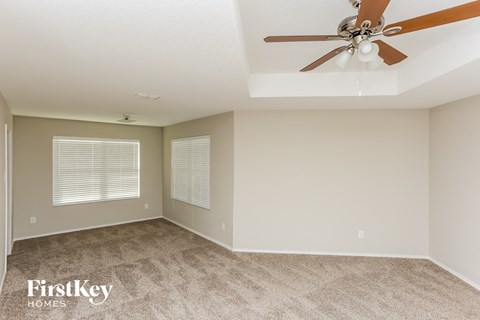 a living room with carpet and a ceiling fan