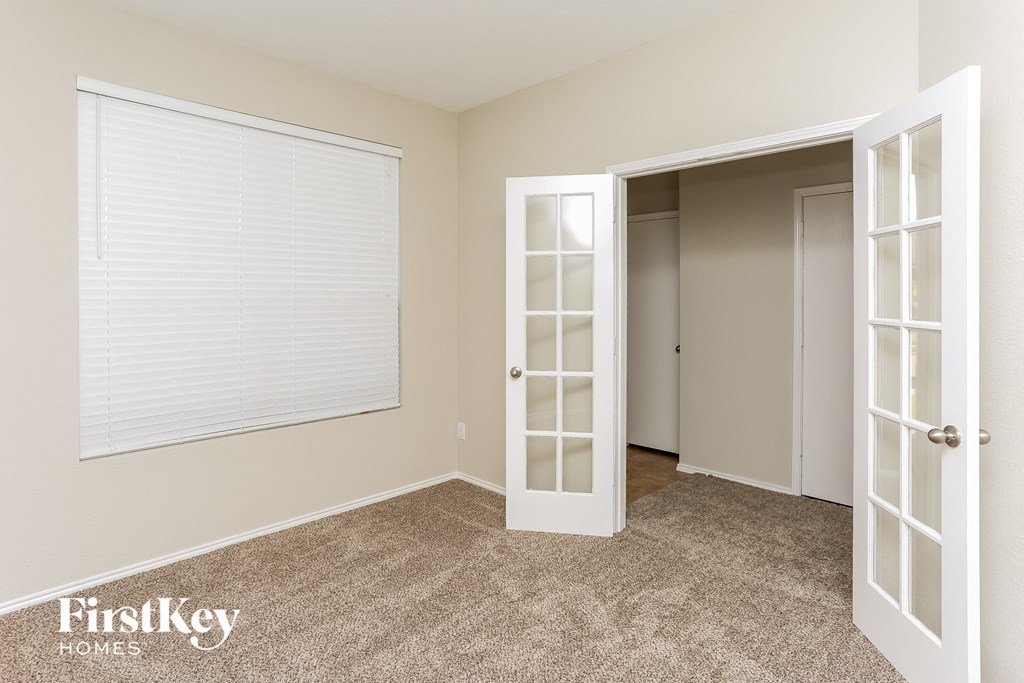 a bedroom with a window and a door to a closet