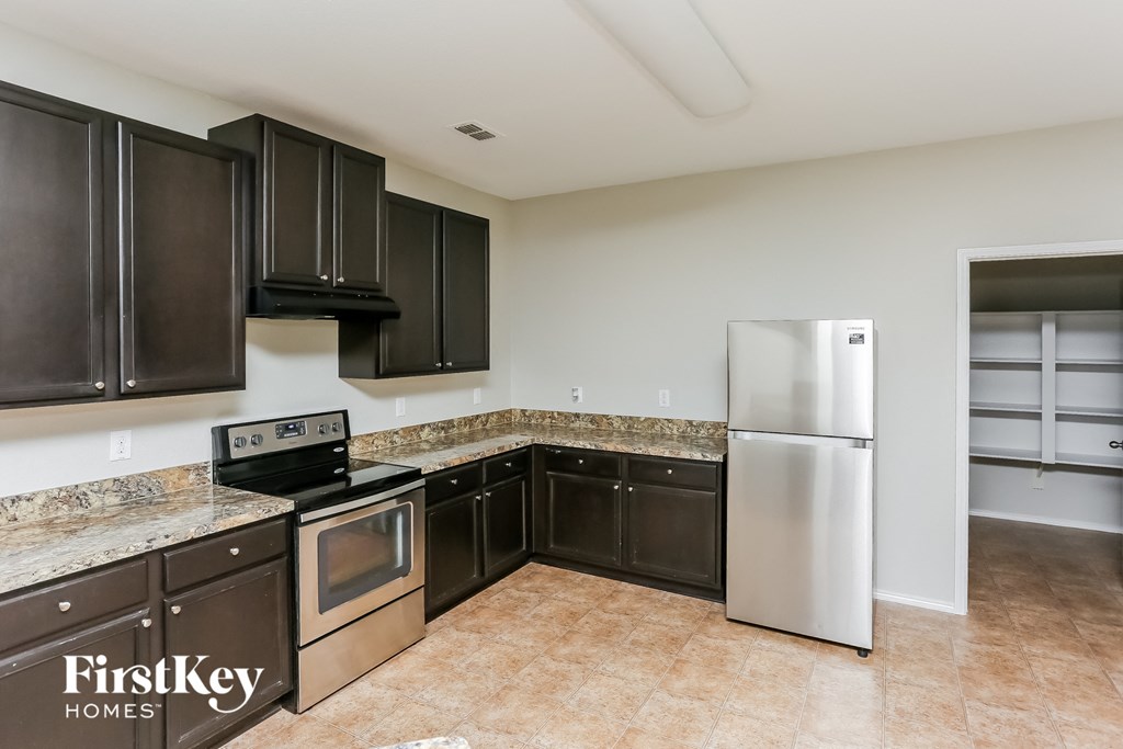 a kitchen with black cabinets and stainless steel appliances
