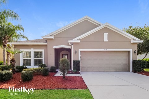 a beige house with a driveway and a garage door