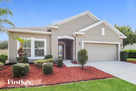 a beige house with a driveway and a garage door
