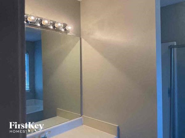 A bathroom with a mirror and lights on the top.