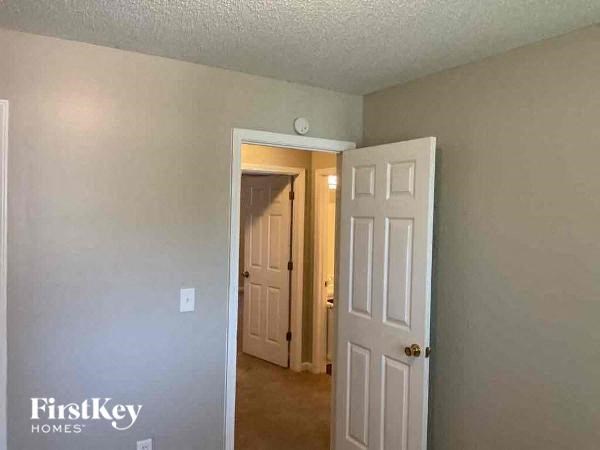 A room with a white door and a wall with a FirstKey Homes logo.