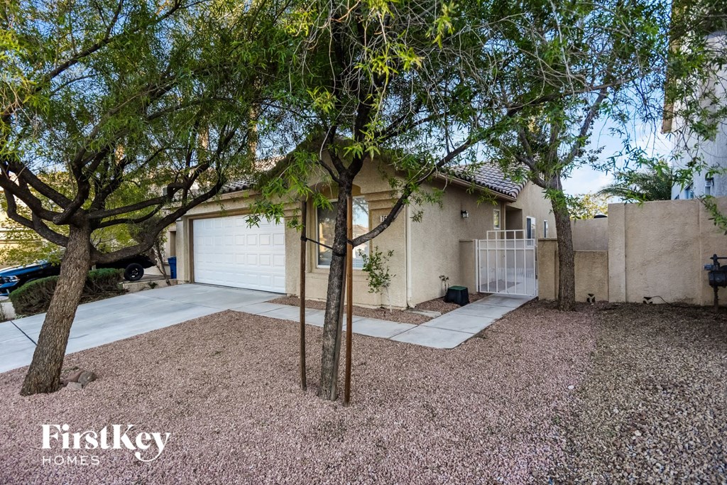 a house with a driveway and trees in front of it