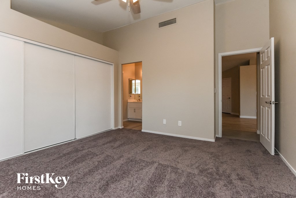 a living room with a carpeted floor and white closets
