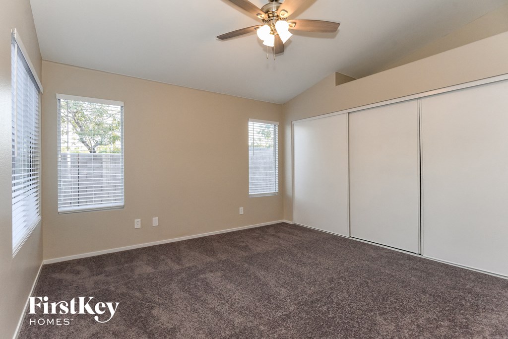 the master bedroom has a large closet and a ceiling fan