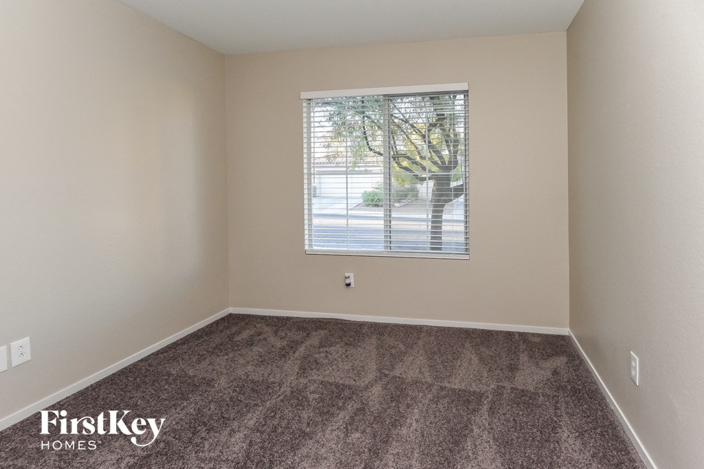 the living room of a home with a window and carpeting