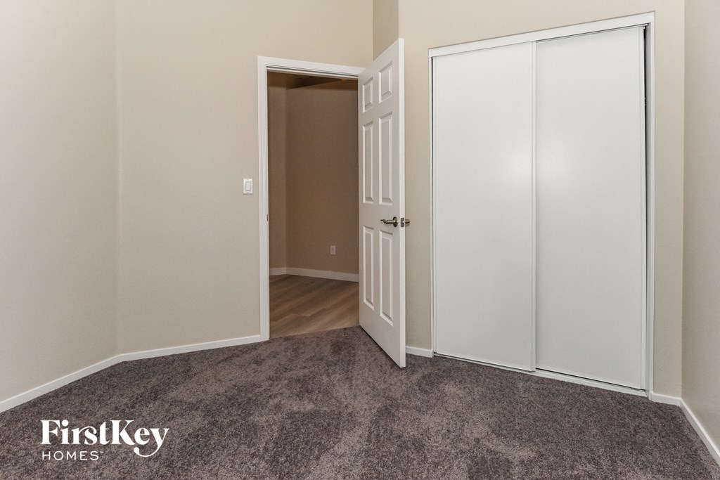 a bedroom with two closet doors and a door to a hallway