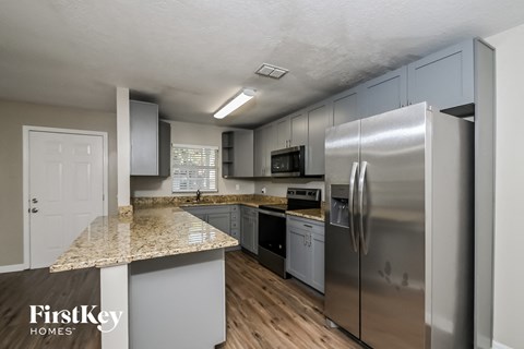 A kitchen with a granite countertop and stainless steel appliances.