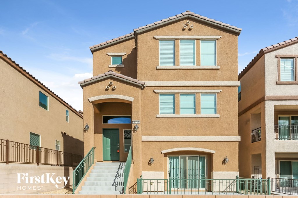 a brick building with stairs and green doors