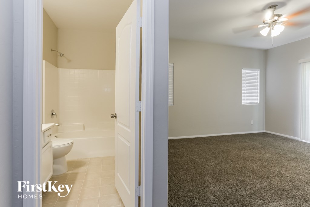 a bathroom with a toilet and a sink and a door open to the bathroom