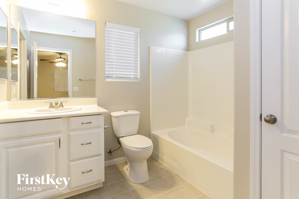 a bathroom with a toilet and a tub and a sink