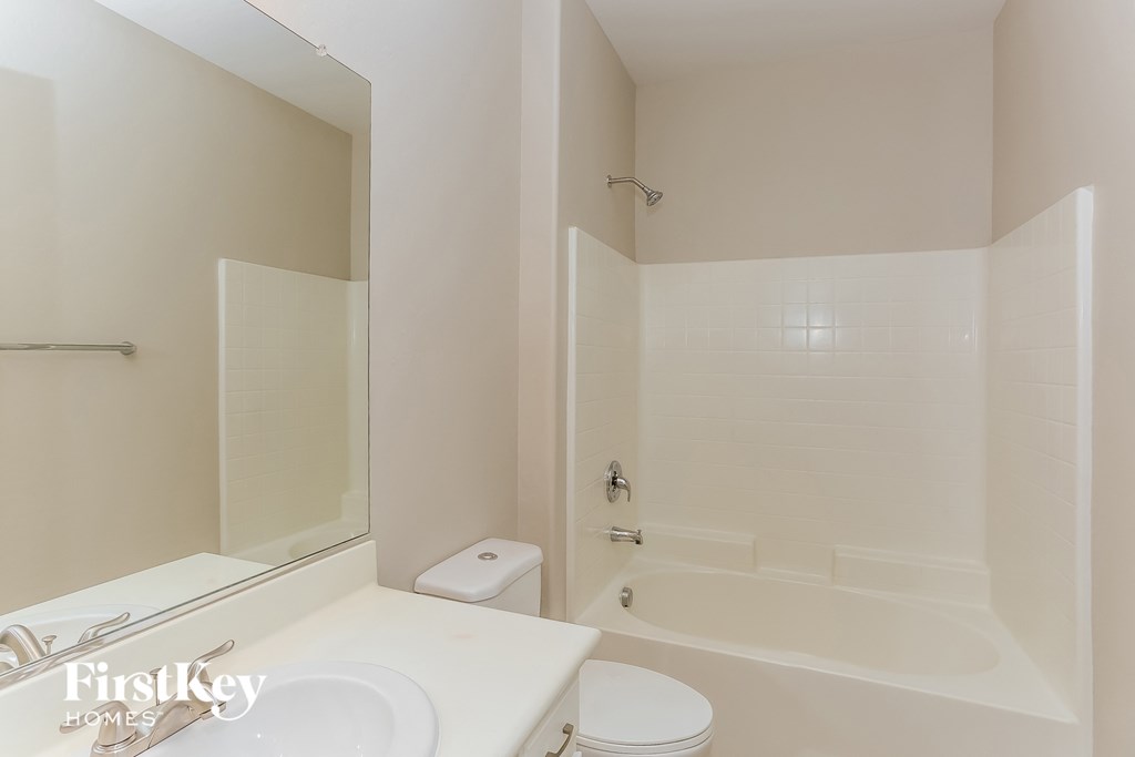 a white bathroom with a tub and a sink and a toilet