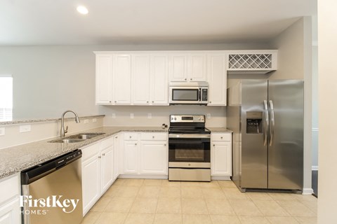 A kitchen with a stainless steel refrigerator, oven, and microwave.