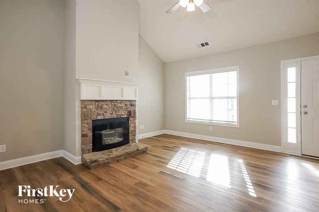 A room with a fireplace and wooden floors.