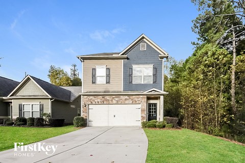 a house with a white garage door in front of a green yard