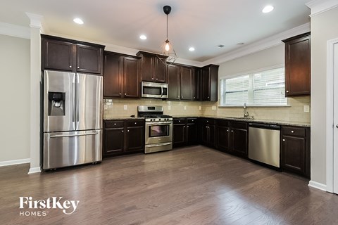 a kitchen with dark wood cabinets and stainless steel appliances
