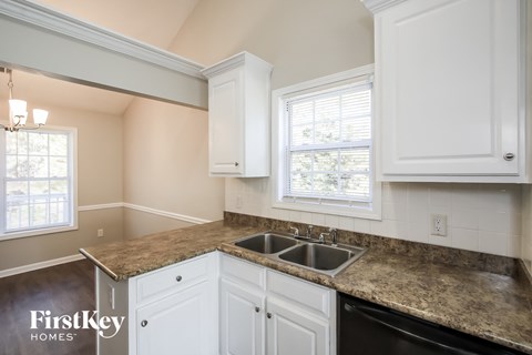 A kitchen with granite countertops and white cabinets.
