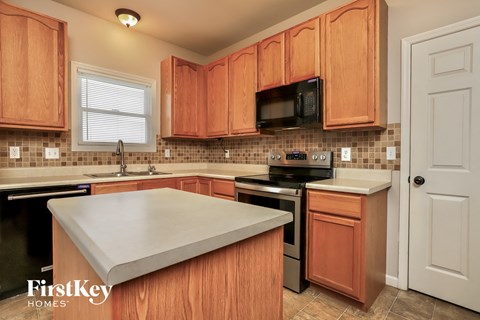 A kitchen with wooden cabinets and a white countertop.