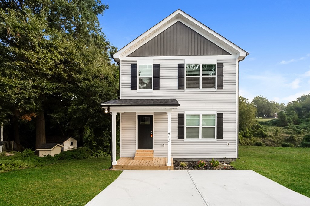 a small white house with a sidewalk in front of it