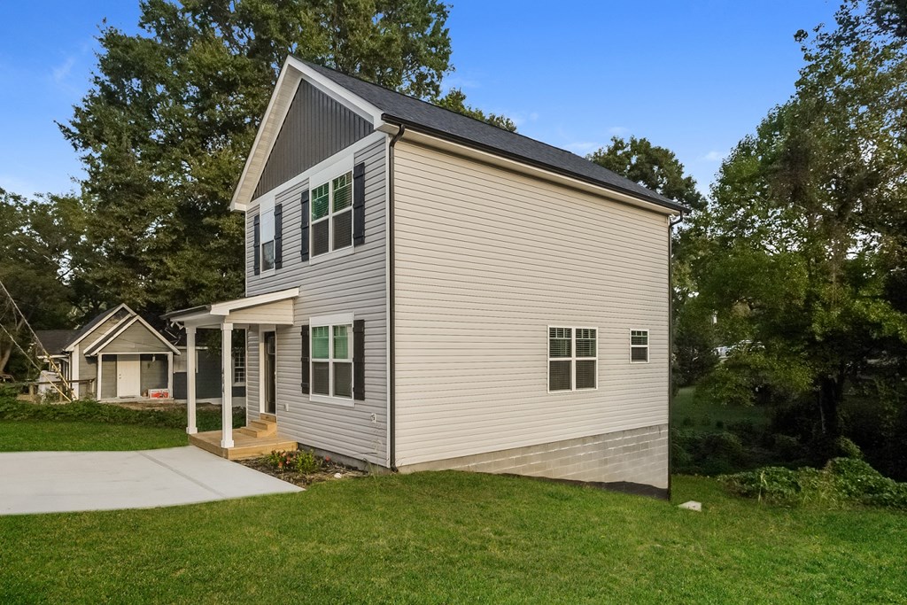 a white house with a gray roof and a sidewalk