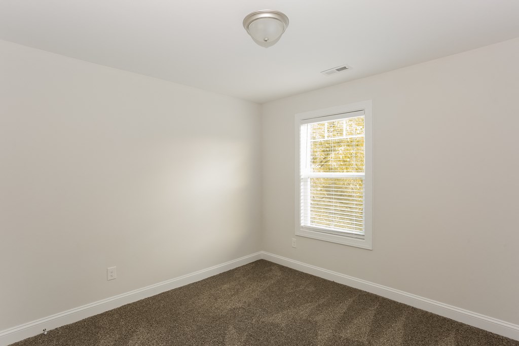 an empty room with carpet and a window