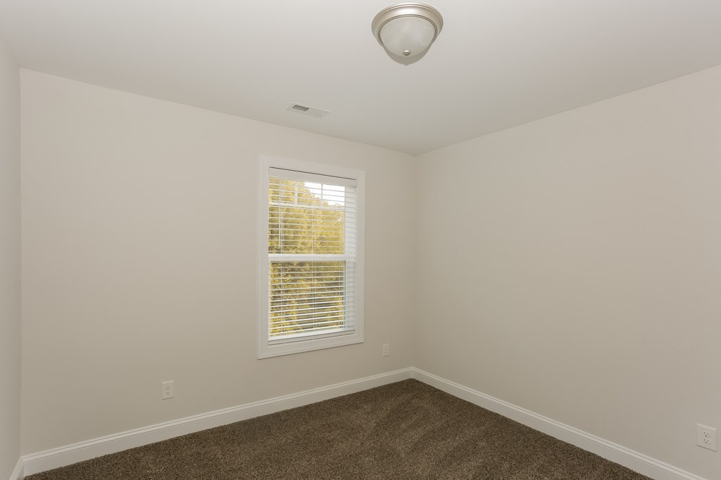 an empty room with carpet and a window