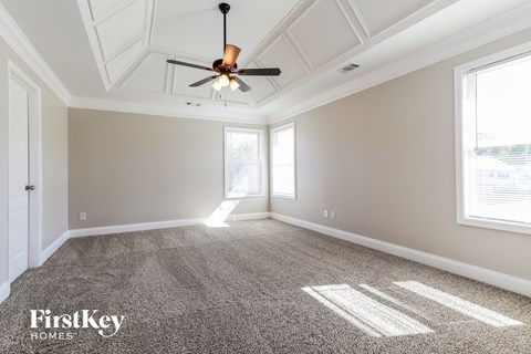 a living room with carpet and a ceiling fan