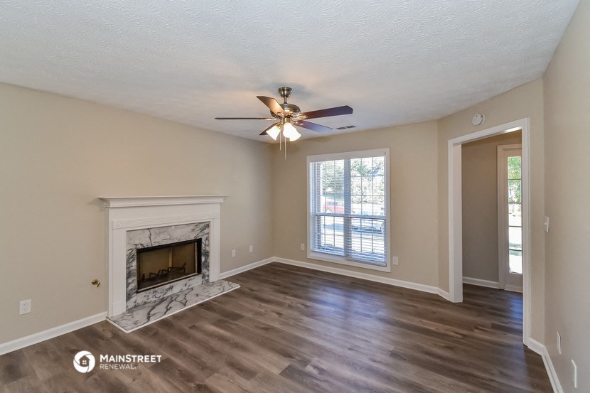 a living room with a fireplace and a ceiling fan
