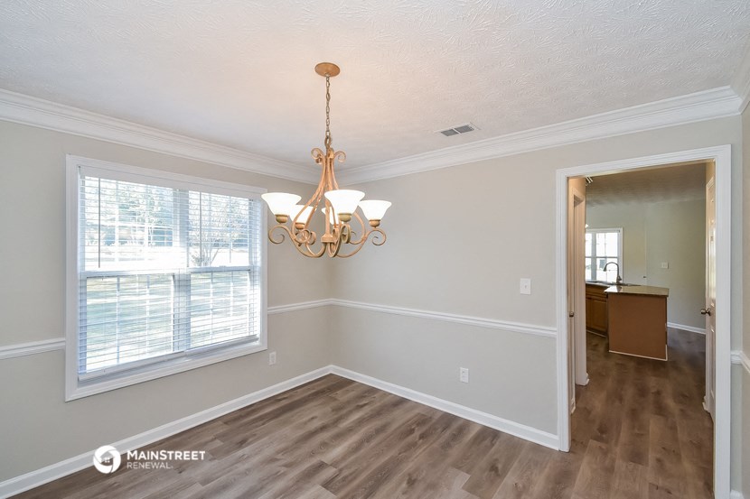 a dining room with a large window and a chandelier
