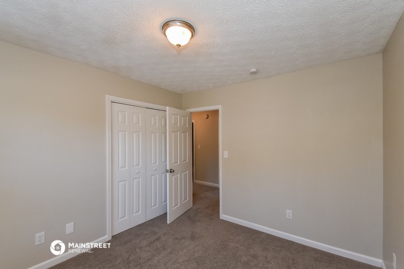 a bedroom with two closets and a door to a hallway