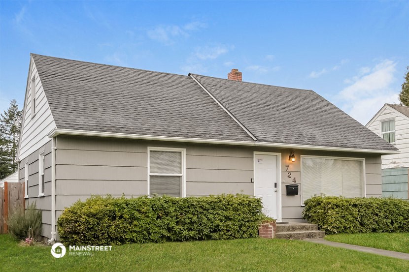 a white house with a gray roof and a white door