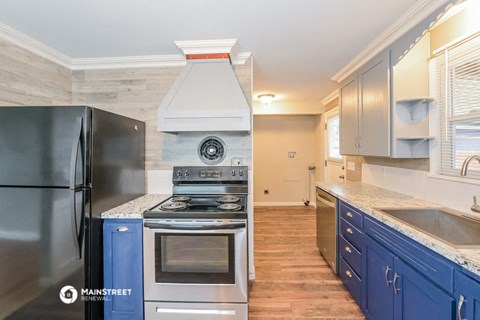 a kitchen with stainless steel appliances and blue cabinets
