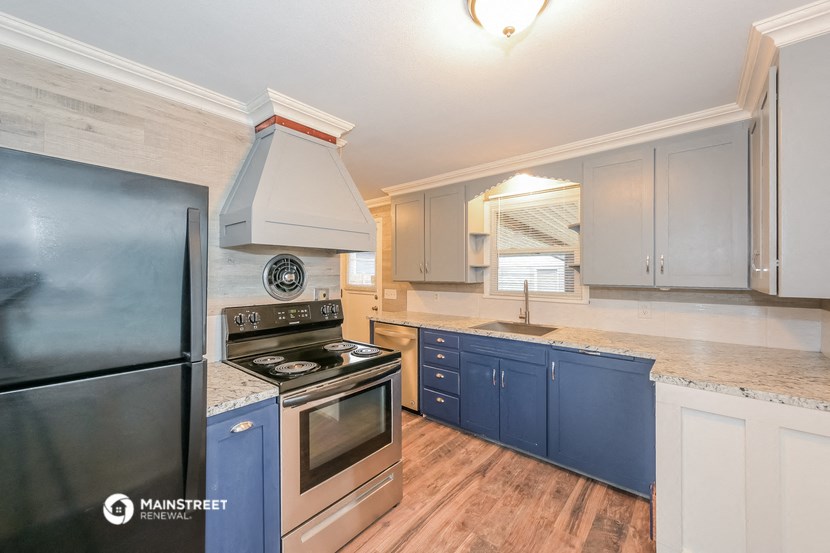 the kitchen has stainless steel appliances and blue cabinets