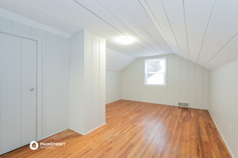the master bedroom has a hard wood floor and a window