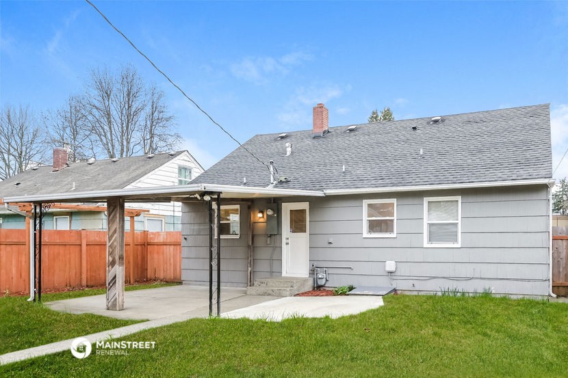 a white house with a porch and a wooden fence