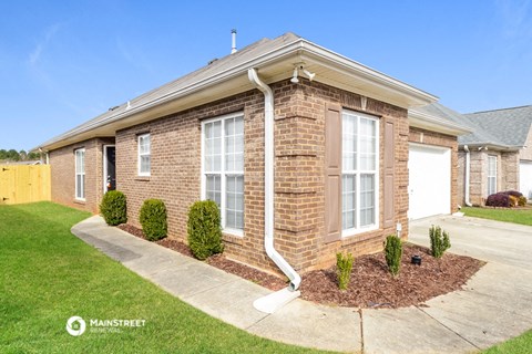 a brick house with white windows and a white gutter