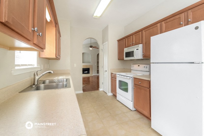 a kitchen with white appliances and wooden cabinets